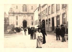 L'inévitable vue de la façade de l'abbatiale. Remarquez sur la droite les maisons qui referment assez fortement la place. Elles seront abattues entre 1933 et 1941. La porte cochère porte l'inscription Distillerie de liqueurs, E. Daniel. Les tentes installées à proximité de l'entrée de l'église abritent les vendeuses de béatilles qui, fidèlement, occupèrent l'endroit jusqu'à la fin des années 1960.